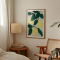 Botanisk citron plakat i gule og grønne nuancer stylet ved seng, lænestol og lampe.