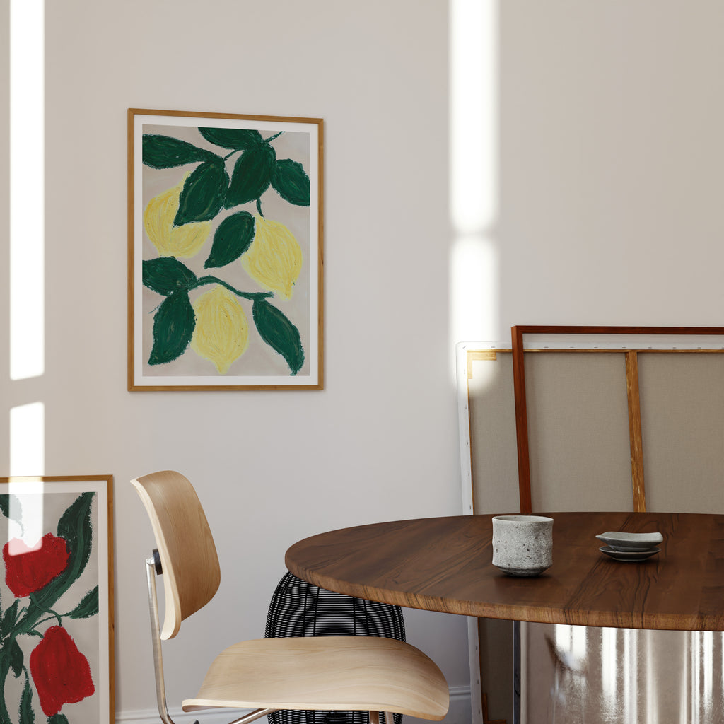 Citron plakat med håndmalet botanisk motiv ophængt over spisebord i lyst og moderne hjem.