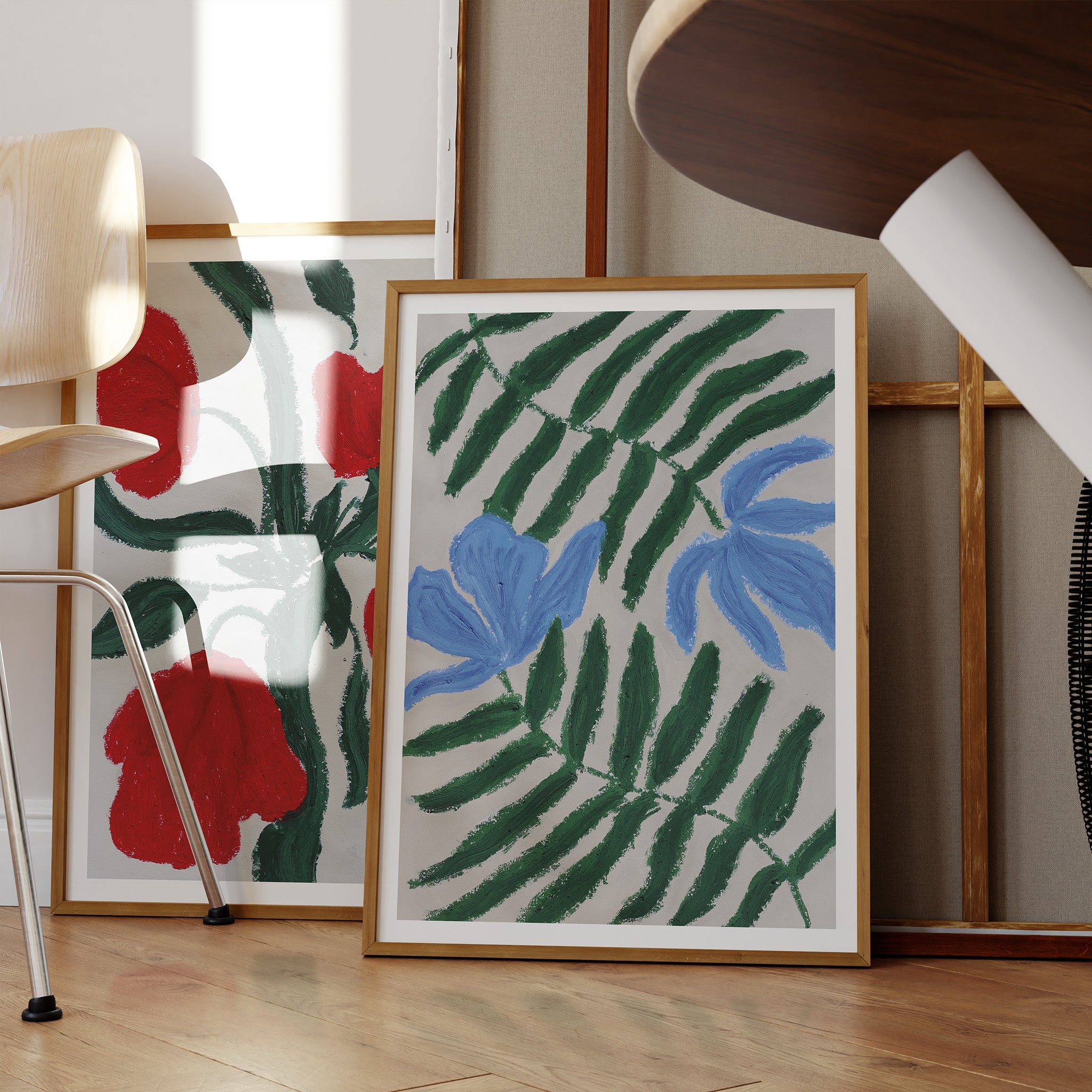 Kunstprint med blå blomster og grønne blade i samspil med andre kunstværker og naturlige materialer