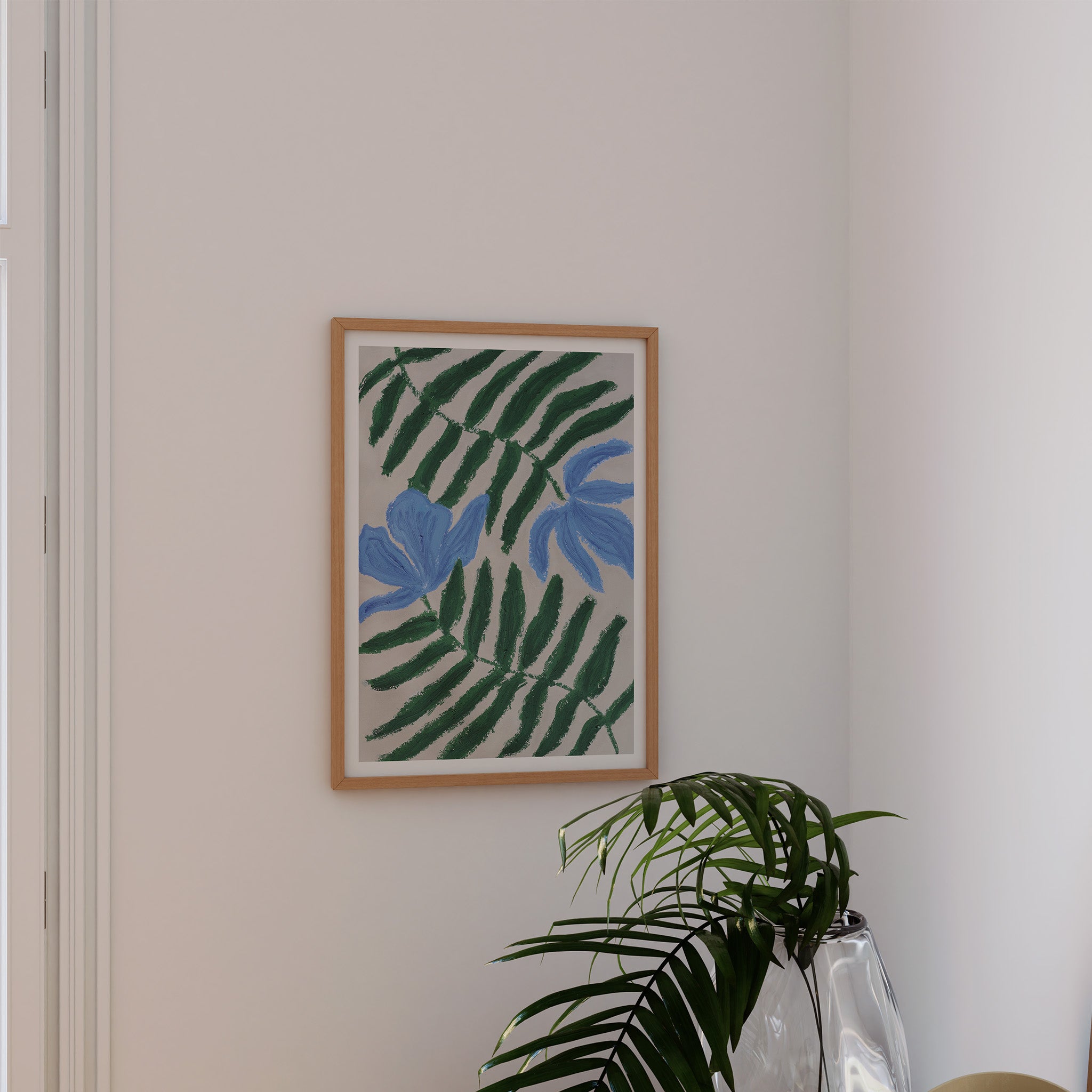 Kunstprint med blå blomster i rolig indretning med grøn plante og naturlige materialer